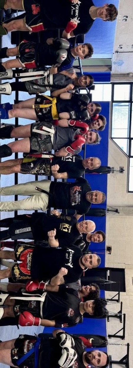 Coach accompagnant un débutant lors d'un cours de boxe à Trazegnies