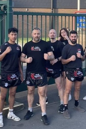Coach accompagnant un adulte débutant en kickboxing à Trazegnies