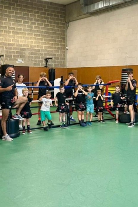 Groupe mixte de jeunes de 8 à 12 ans pendant un cours de boxe éducative à Trazegnies