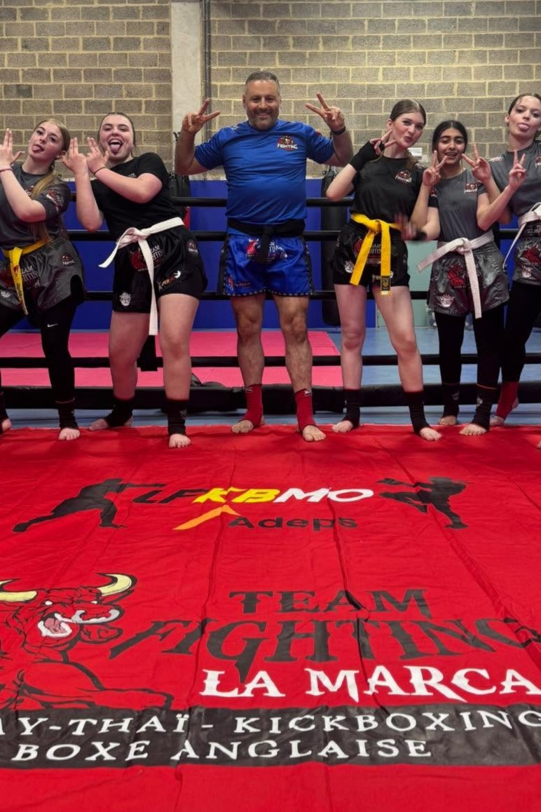 Coach encadrant un adolescent pendant un cours de boxe à Trazegnies